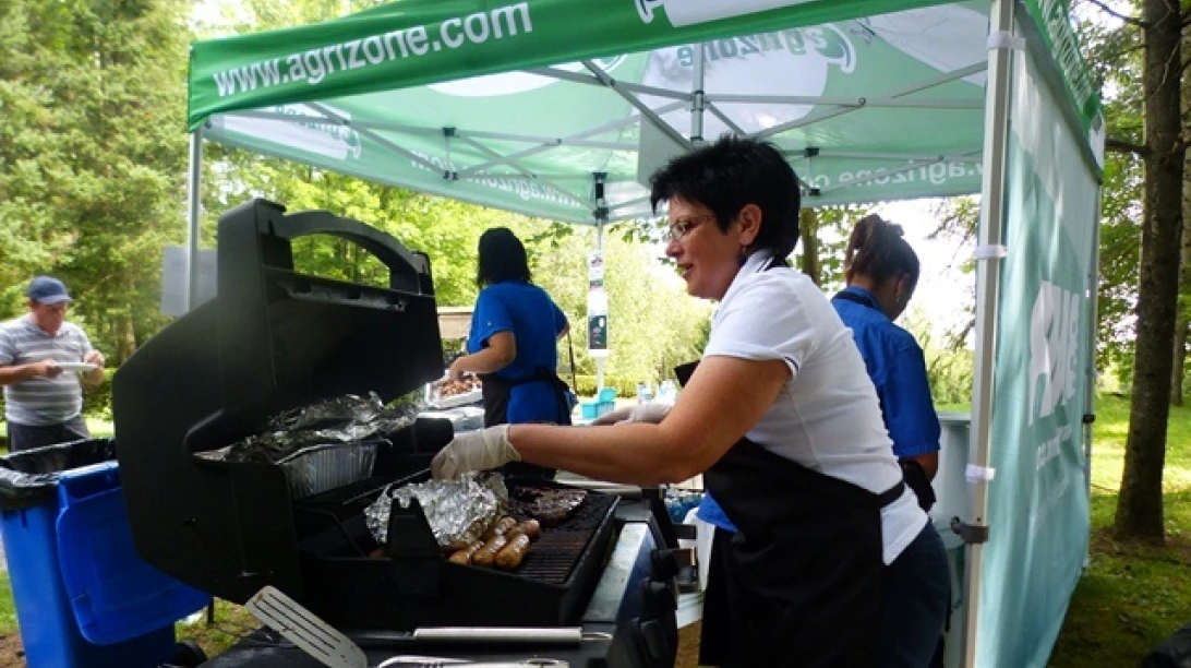 Photo de personnes préparant un barbecue pour les participants et les spectateurs du tournoi de golf.