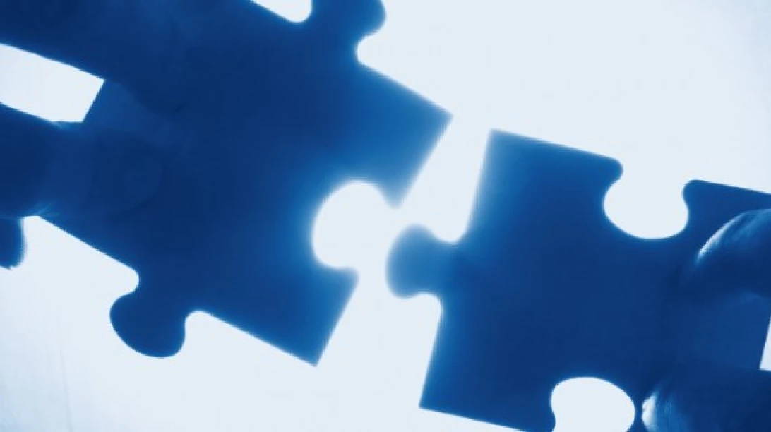 Pièces de puzzle en train de s'assembler.