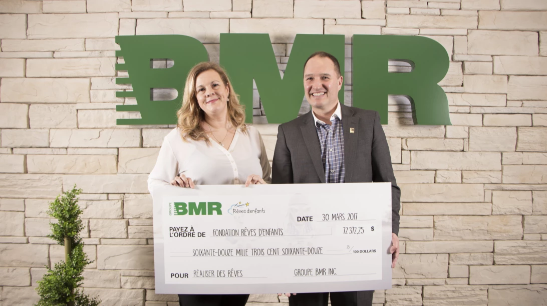 Chef de la direction du Groupe BMR en train de remettre un chèque.