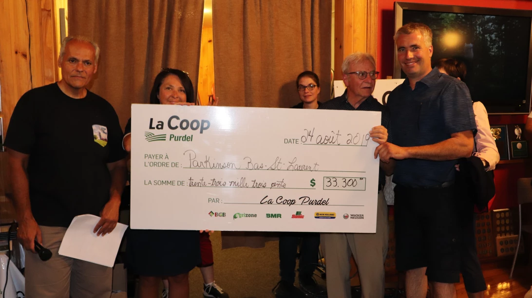 Personnes tenant un chèque de trente-trois milles dollars de la part de La Coop Purdel.
