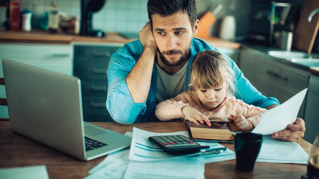 Père de famille stressé devant des documents