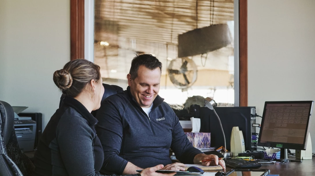 Couple de producteurs s'affairant à la planification des champs dans un bureau.