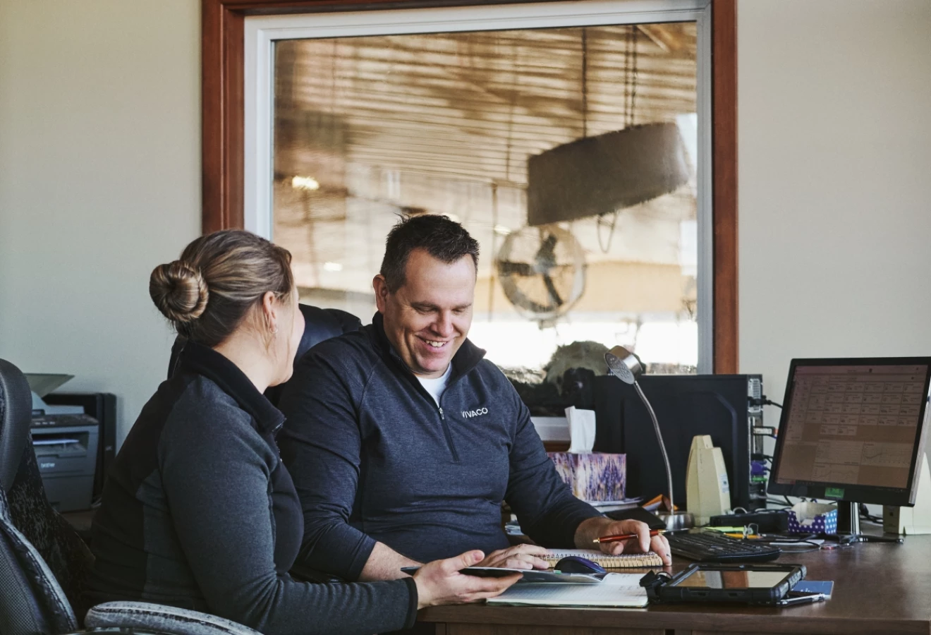 Couple de producteurs s'affairant à la planification des champs dans un bureau.