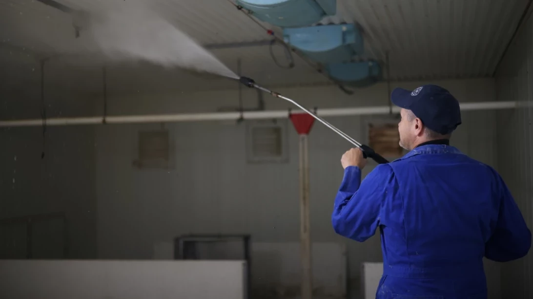 Jean-François Roy nettoyant son bâtiment porcin