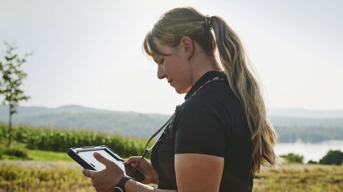 Une experte-conseil de Sollio Agriculture consule une tablette dans un champs