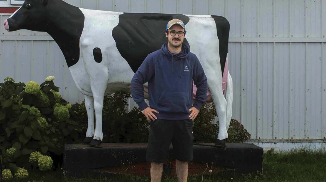 Mathieu Normand devant une statue de vache
