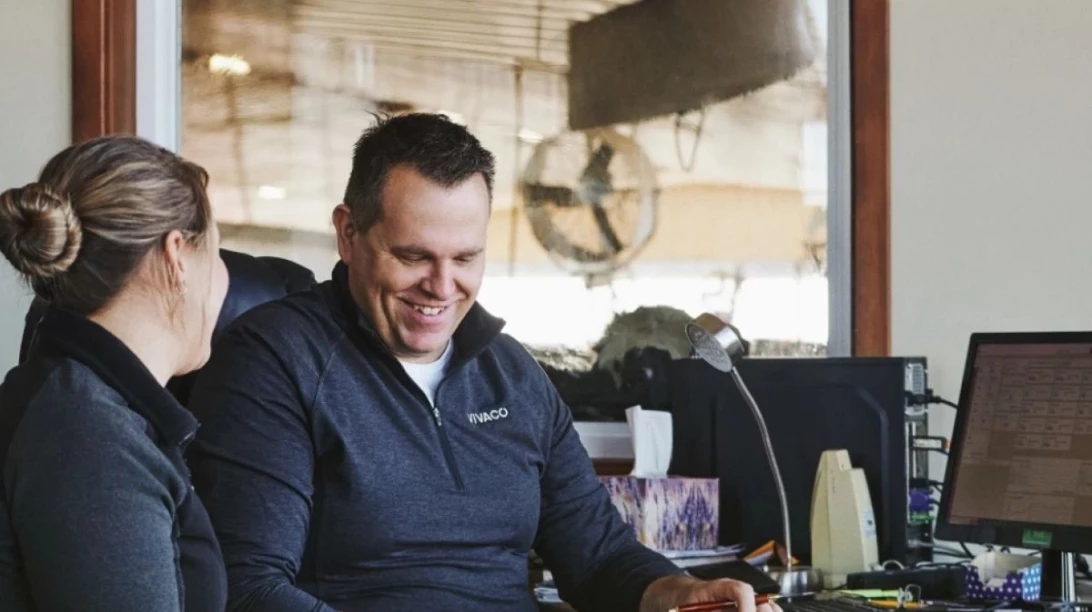 Couple de producteurs s'affairant à la planification des champs dans un bureau.