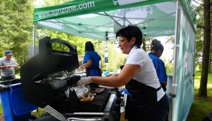 Photo de personnes préparant un barbecue pour les participants et les spectateurs du tournoi de golf.
