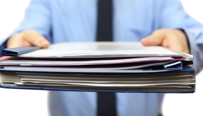Image de quelqu'un en train de donner des documents à quelqu'un.