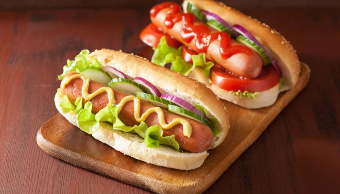Deux hot-dogs sur une planche de bois.