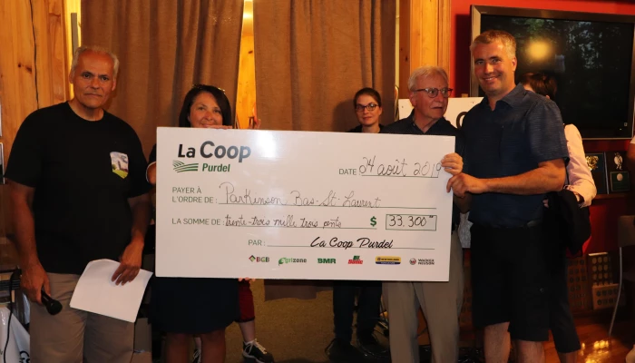 Personnes tenant un chèque de trente-trois milles dollars de la part de La Coop Purdel.