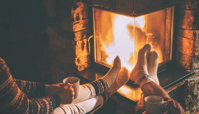 Personnes qui se réchauffent les pieds devant un feu