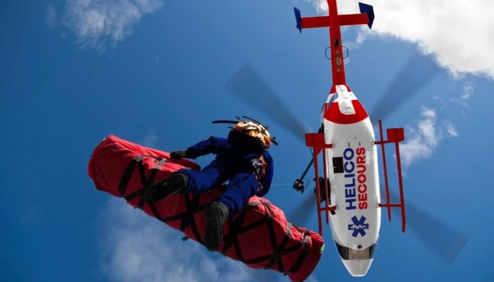 Secouriste qui descend d'un hélicoptère Helico Secours.