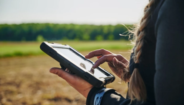 Une experte-conseil de Sollio Agriculture entre des données de champ sur une tablette.