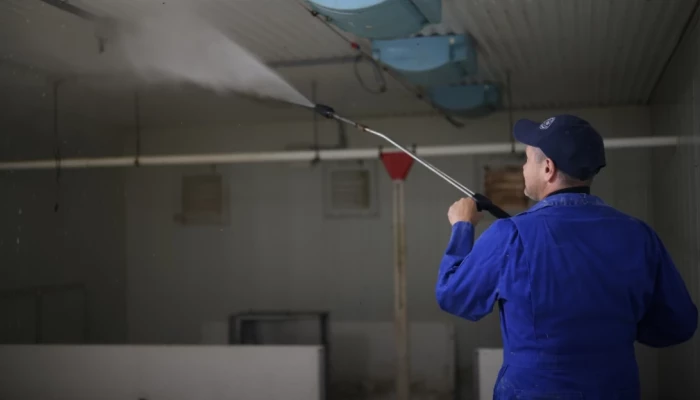 Jean-François Roy nettoyant son bâtiment porcin
