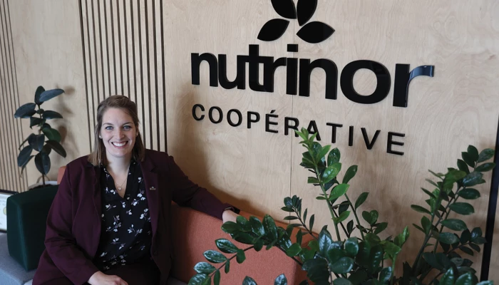 Pascale maltais, assise devant le logo de Nutrinor