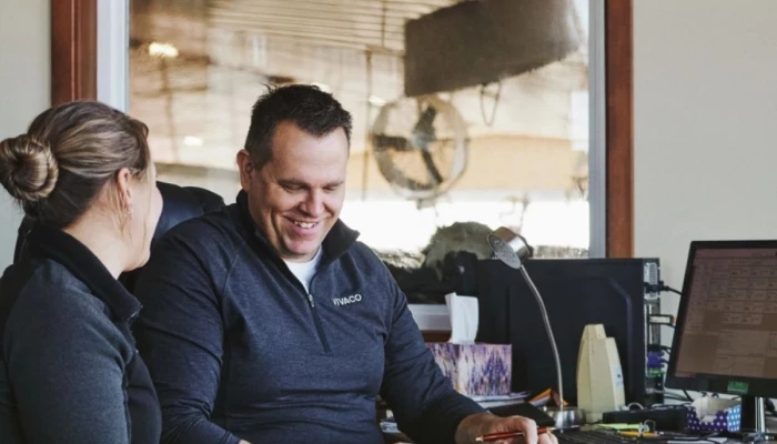 Couple de producteurs s'affairant à la planification des champs dans un bureau.