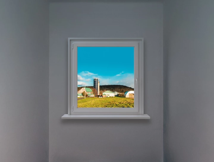 Fenêtre qui montre une ferme ensoleillée