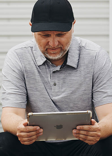 Un homme lit un article sur sa tablette.
