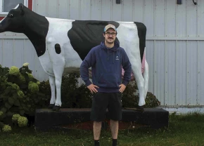 Mathieu Normand devant une statue de vache